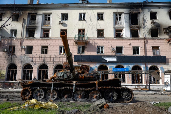 A destroyed tank and a damaged apartment building from heavy fighting are seen in an area controlled by Russian-backed separatist forces in Mariupol, Ukraine, Tuesday, April 26, 2022. (AP Photo/Alexei Alexandrov) ORG XMIT: MAR151